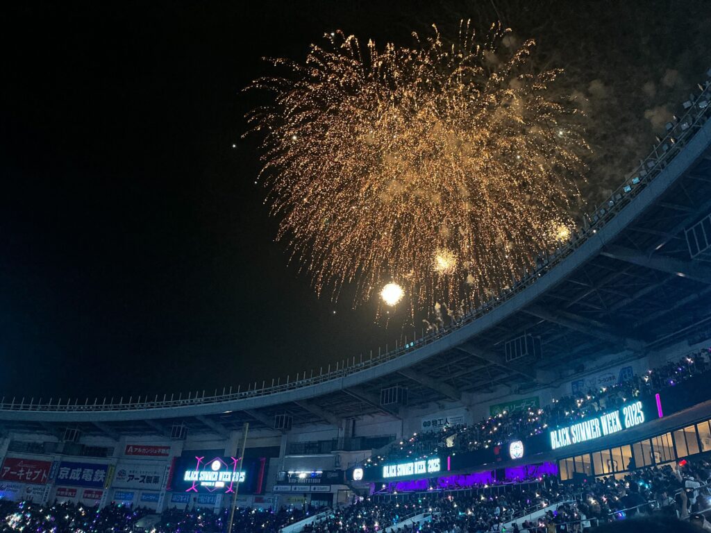 スタジアムの観客席の後ろに花火が上がっている。