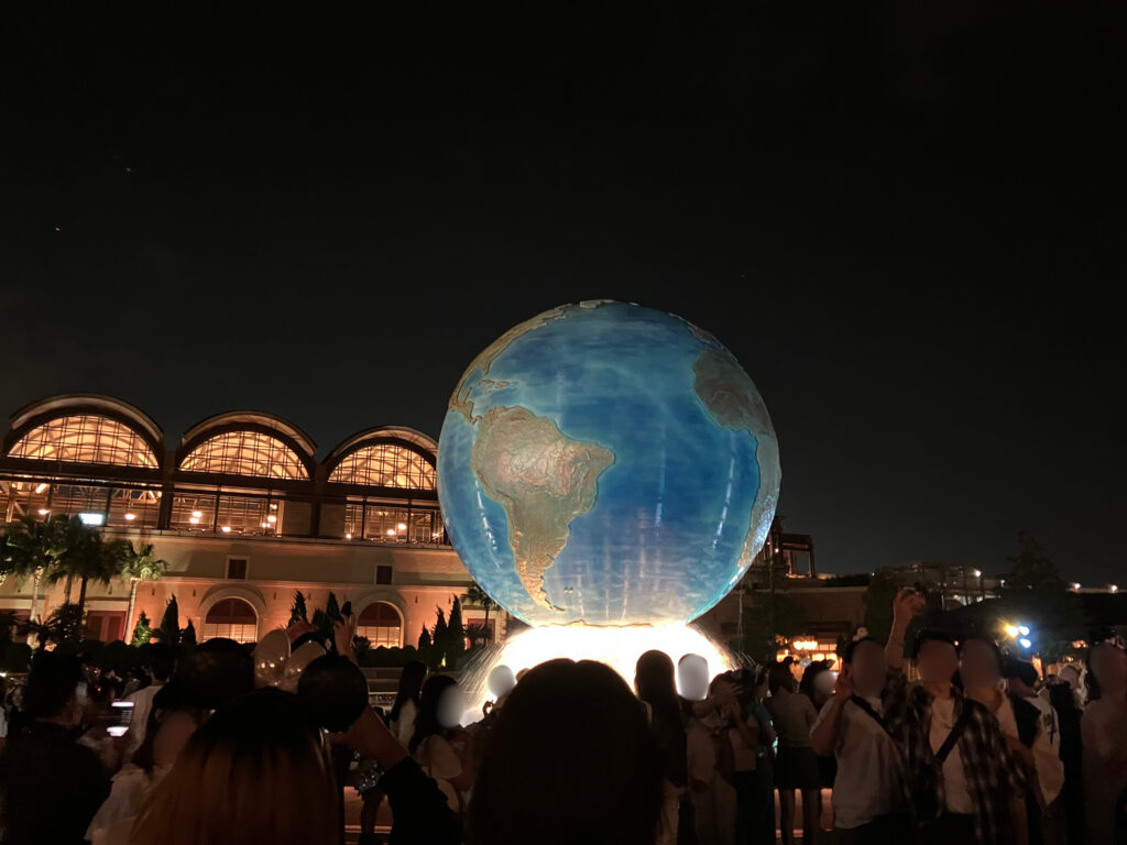 夜になった東京ディズニーシーの様子。エントランスからすぐの場所にあるアクアスフィアがライトアップされ輝いている。